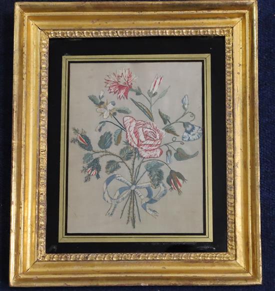 A pair of Regency silkwork panels of floral sprays, eglomise framed